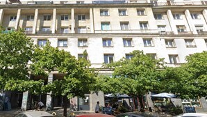 A multi-story building with balconies, a courtyard with trees, and outdoor seating. - Elegant Apartment near Vitsula River (Warszawa)