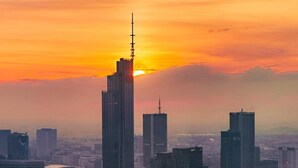 Une vue d’une ville avec de nombreux gratte-ciel, prise au coucher du soleil.