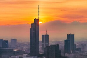 A cityscape with multiple high-rise buildings during sunset. - Modern Romantic CIty Getaway (Warszawa)