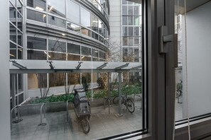 A modern building with large windows, a covered outdoor seating area, and bicycles parked outside. - Modern Romantic CIty Getaway (Warszawa)