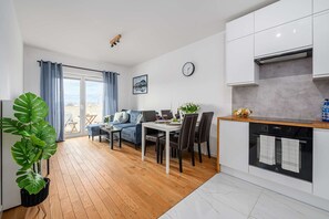 Ein modernes Apartment mit Essbereich, Küche und einem Balkon mit Blick.
