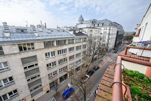 A multi-story building with a flat roof, a street with parked cars, and a clear sky. - Charming Warsaw Apartment for 6 (Warszawa 2)