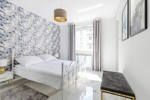 A modern bedroom with a bed, bedside table, lamp, and a view of the outside. - Luxurious Flat with magnificent sea view (Łódź)