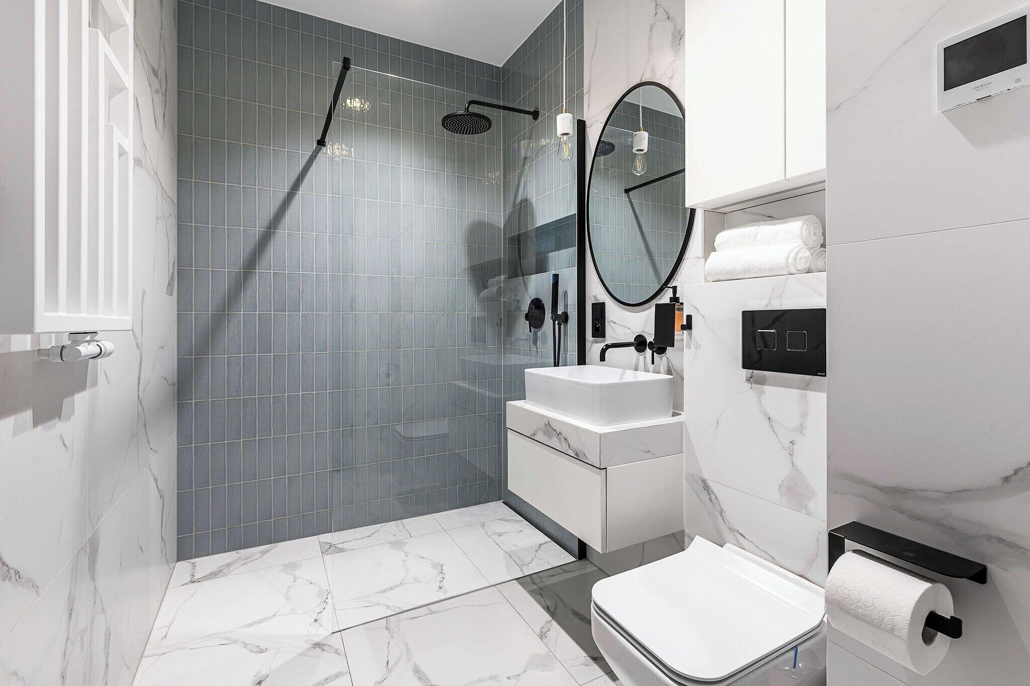 Ein modernes Badezimmer mit Dusche, Waschbecken und Toilette.