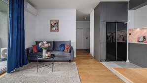A modern living room with a grey sofa, a coffee table, and a blue curtain. - Magnificent seafront duplex in Porspoder (Łódź)