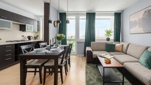 Um apartamento moderno com área de refeições, cozinha e sala de estar.