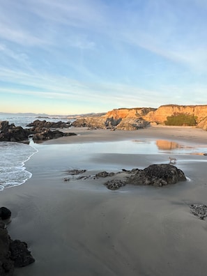 A beach with rocky outcrops and a calm sea.