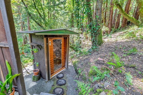 A small wooden structure with a door, a window, and a step leading to it.