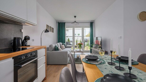 Eine moderne Küche mit Essbereich, einer Couch und einem Fernseher.
