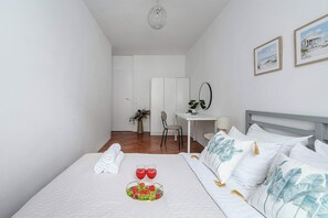 Ein Hotelzimmer mit Bett, Schreibtisch, Stuhl, Spiegel und Blick auf den Strand.