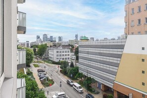 Ein Hochhaus mit Parkplatz und Blick auf eine Skyline mit modernen Gebäuden.