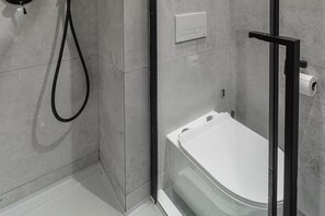 Ein modernes Badezimmer mit Toilette, Dusche und Handtuchhalter.