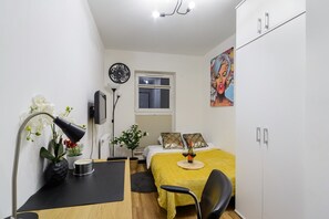 A compact bedroom with a bed, bedside table, lamp, and a painting on the wall. - Mansion Haven in Lannilis for 8 (Łódź)