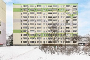 Un immeuble résidentiel à plusieurs étages, doté d’une façade plane, de nombreux balcons et d’un escalier central.