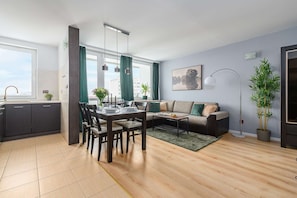 A modern living room with a dining area, a sofa, a coffee table, and a large window with curtains. - Warsaw Flat near Old Town (Warszawa)