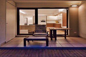 Ein modernes Interieur mit einer Sitzecke, einem Tisch und Blick in einen angrenzenden Wohnbereich.