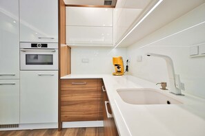 A modern kitchen with a built-in oven, a coffee machine, and a sink. - City Apartment for 6 guests (Warszawa)