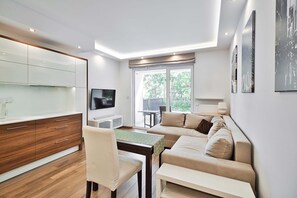 Ein modernes Wohnzimmer mit einer Couch, einem Esstisch und einem Fernseher.