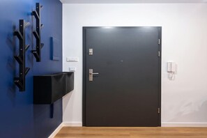 A room with a dark door, a light switch, and a wall-mounted telephone. - Pretty House by the Sea for 4 (Łódź)
