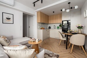 A modern apartment with a living room, dining area, and kitchen. - Elegant Family Apartment in Nowolipki (Warszawa 2)