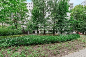 A landscaped area with mature trees, a hedge, and a paved walkway. - House in Saint-Pabu near Stunning Beaches (Warszawa 2)