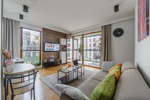 Ein modernes Wohnzimmer mit Sofa, Couchtisch und Fernseher.
