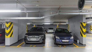 Ett parkeringsgarage med två bilar parkerade på anvisade platser, markerade med numren 72 och 73.