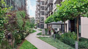 A pathway leading to a building with a sign that reads 'Frank.' - City Apartment with Balcony (Warszawa)