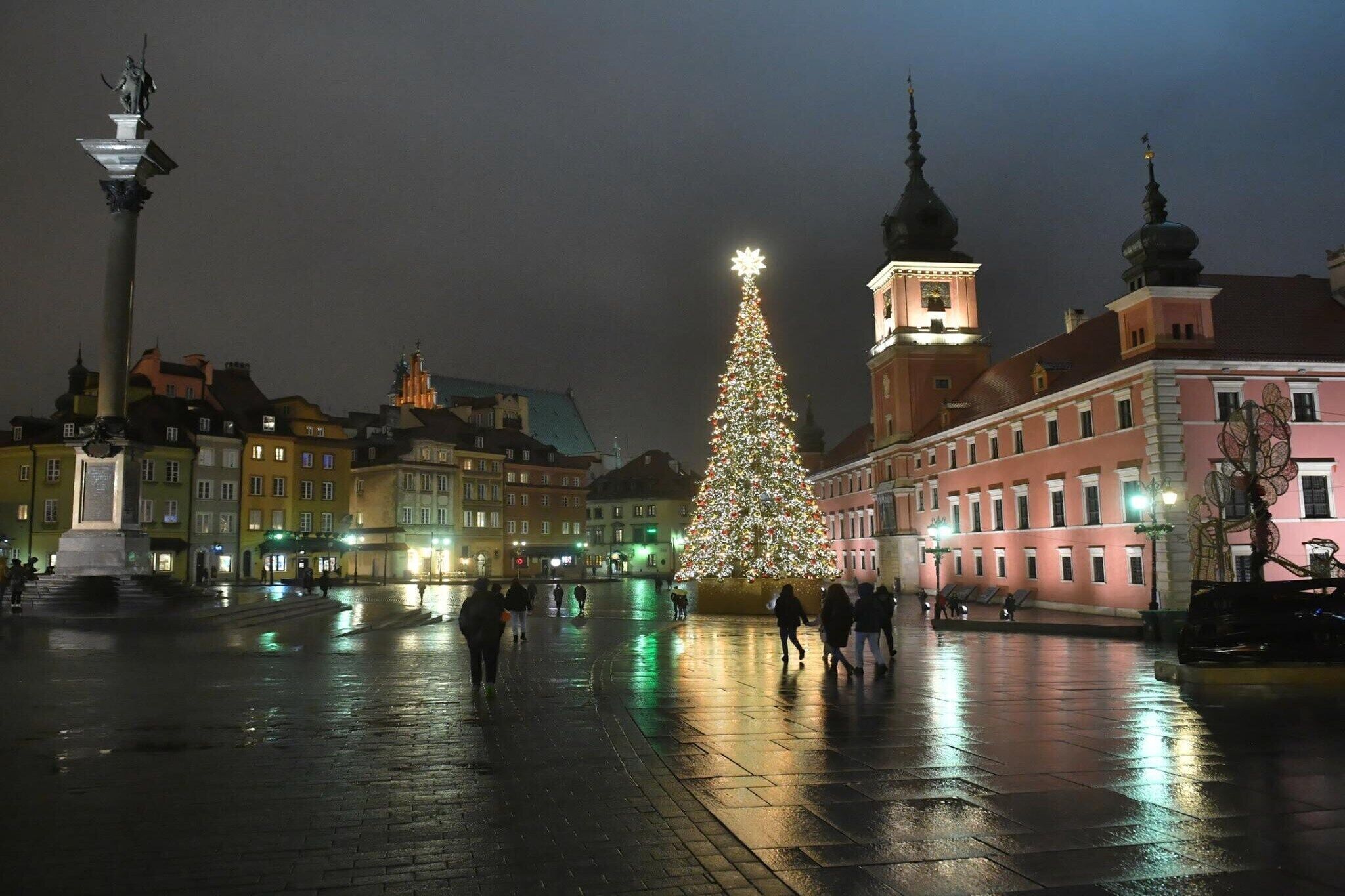 A square with a large Christmas tree and a statue.