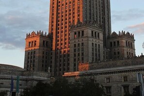 Ein großes, mehrgeschossiges Gebäude mit einem markanten zentralen Turm und symmetrischen Flügeln.