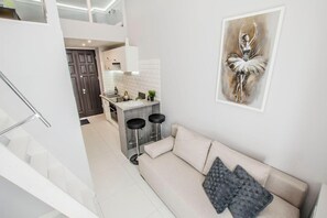 Eine moderne Wohnung mit Wohnzimmer, Küche und Treppe.