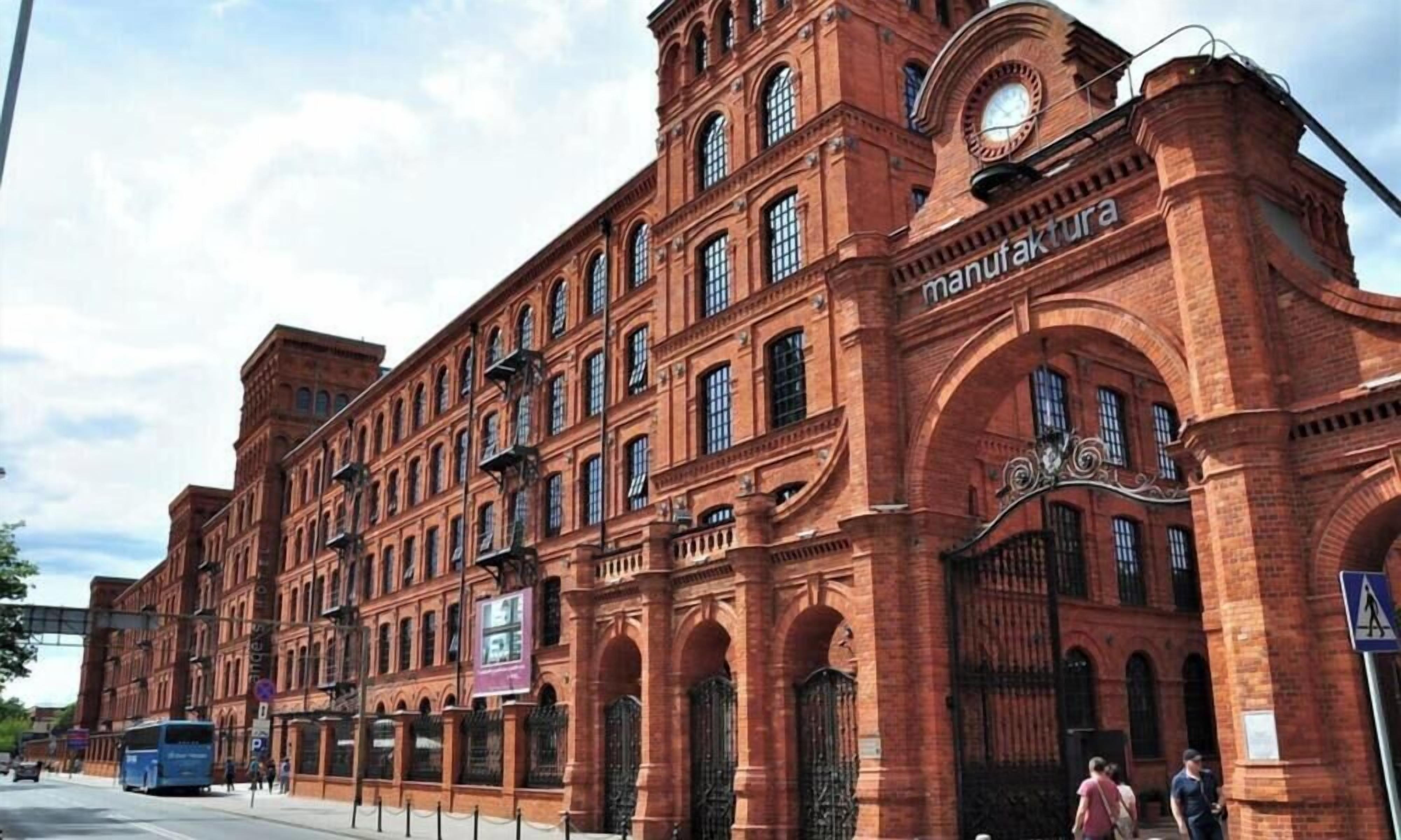 A large brick building with multiple windows and a clock tower.