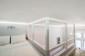 Ein Schlafzimmer mit einem Himmelbett, einem Nachttisch und einer wandmontierten Lampe.
