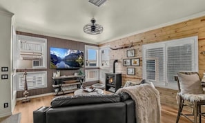 A cozy living room with a fireplace, a television, and a comfortable seating area.