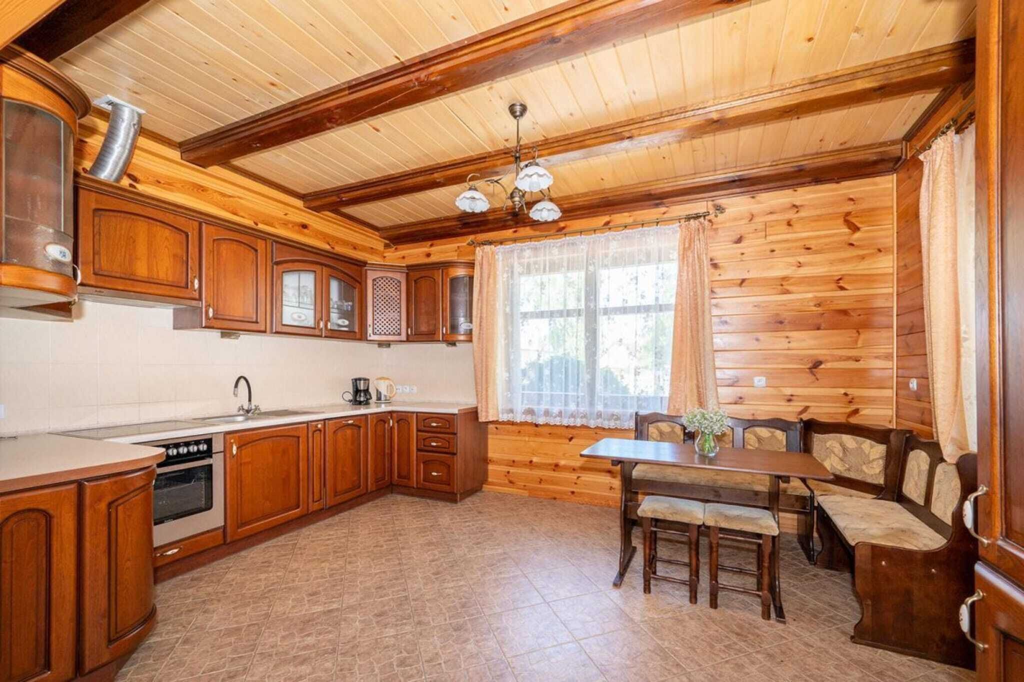 A wooden interior with a kitchen, dining table, and chairs.