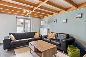 Ein modernes Wohnzimmer mit einem Ecksofa, einem Couchtisch aus Holz und einer Lampe.