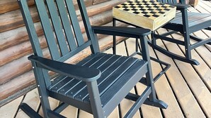 To gyngestole med et skakspil på en træterrasse.