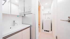 Un bany modern amb un rentapans blanc, un aixeta cromada i un mirall a la part superior.