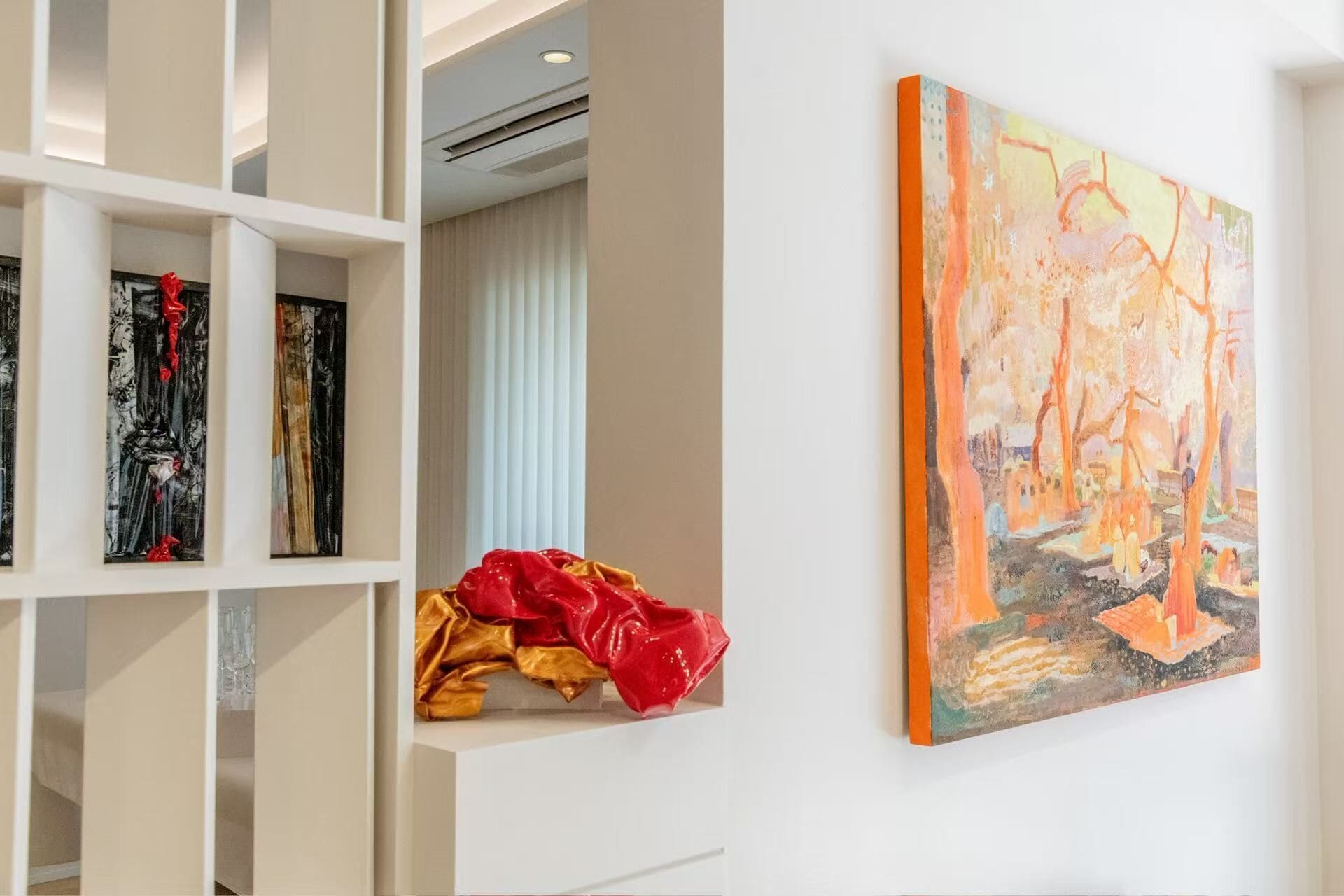 A room with a white wall, a painting, and a shelf with various items.