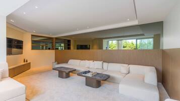 Una sala de estar moderna con un sofá modular, una mesa de centro y un televisor integrado.