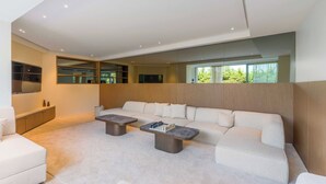 A modern living room with a sectional sofa, a coffee table, and a built-in TV. - High-end Apartment With Spacious Terrace (Villefranche-sur-Mer)