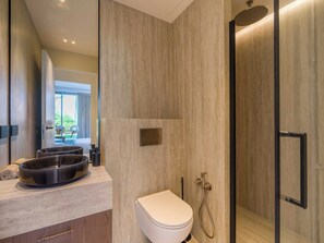 Ein modernes Badezimmer mit Toilette, Bidet und Duschbereich.