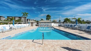 A swimming pool with lounge chairs and palm trees. - ☀️Beach Front-Sunset Views | Pool and Easy Beach Access | Sand Caper #702 🌴 (Fort Myers Beach)