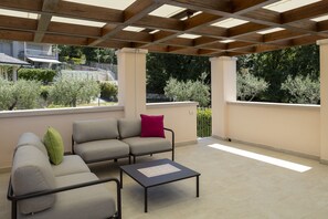 An outdoor patio with a sofa, a coffee table, and a pergola structure. - Towerhill Apartment with Roofterrace and shared Po (Torri del Benaco)