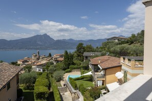 A residential area with a pool, a mountain in the background, and a view of a lake. - Towerhill Apartment with Roofterrace and shared Po (Torri del Benaco)