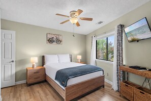 A bedroom with a bed, bedside lamps, a ceiling fan, a window with a view, and a mounted television. - ⭐Walk to Beach | Crystal Village II 15B | Community Pool 🏊️ (Miramar Beach)