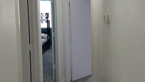 A narrow hallway with a door leading to a bedroom. - Perfect Getaway Near Disney & Universal (Davenport)