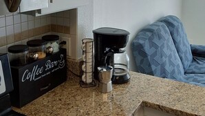 Ett kök med en kaffemaskin, en kaffestation och en mikrovågsugn.