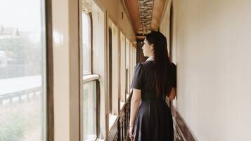 A person standing by a train window, looking outside.