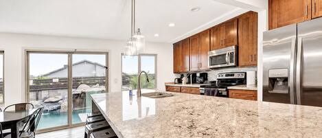 A modern kitchen with granite countertops, stainless steel appliances, and wooden cabinets.